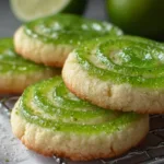 A plate of vibrant lime jello sugar cookies decorated with green sprinkles and lime slices