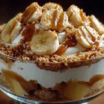 A bowl of creamy banana pudding layered with Biscoff cookies and banana slices